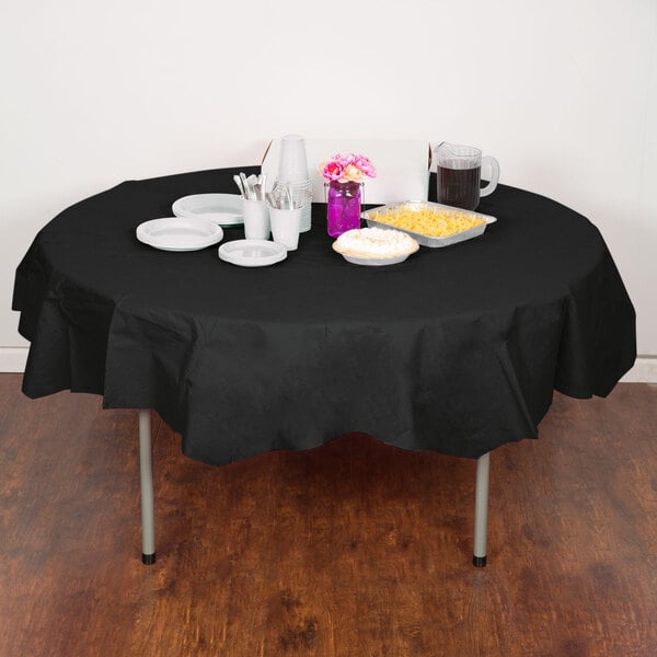 A table with a black Creative Converting OctyRound table cover and food and drinks on it.