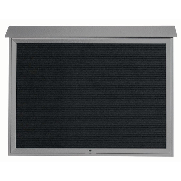 A light grey Aarco message center door with a black letter board and black screen.