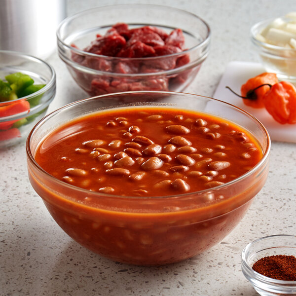 A bowl of Furmano's spiced chili beans in a sauce with other food items.