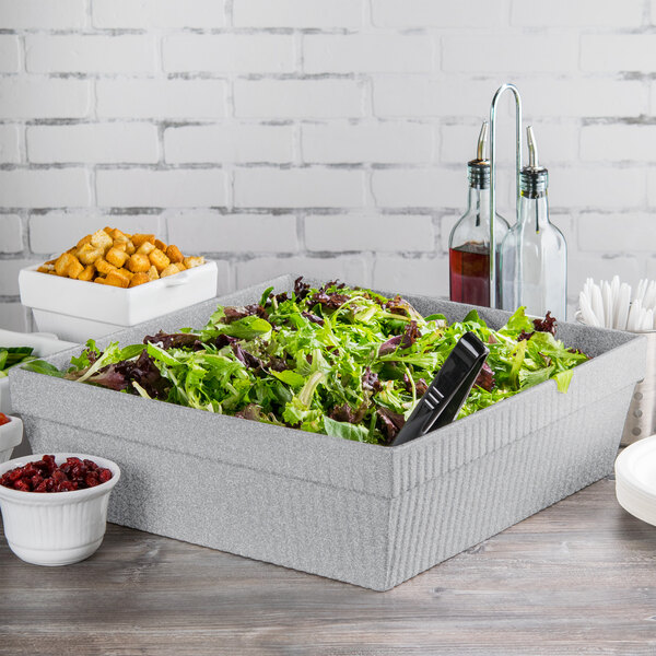 A Tablecraft granite cast aluminum square bowl filled with salad on a table.