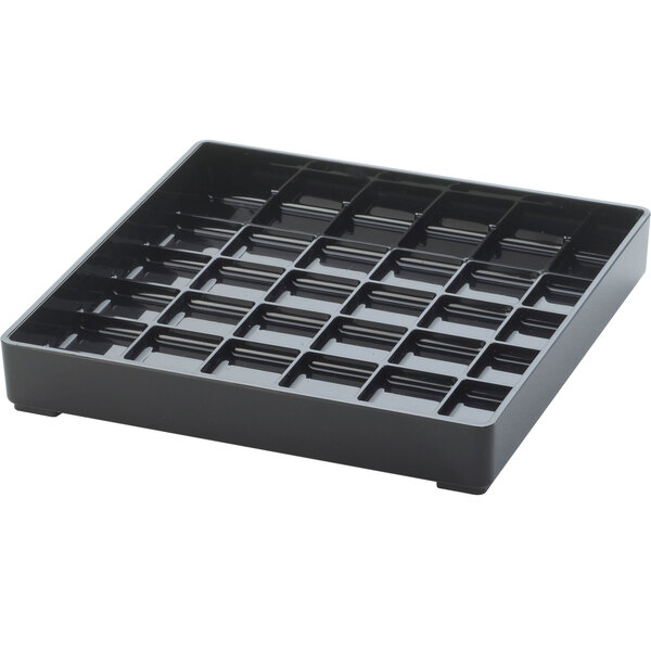 A black plastic Cal-Mil square drip tray with many compartments.