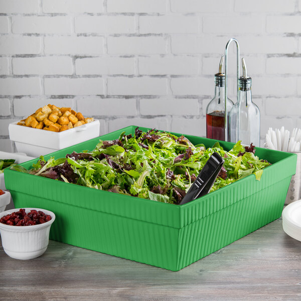 A Tablecraft green cast aluminum square bowl with salad in it.
