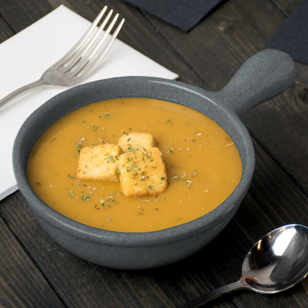 A Tablecraft granite cast aluminum soup bowl with croutons and a fork.