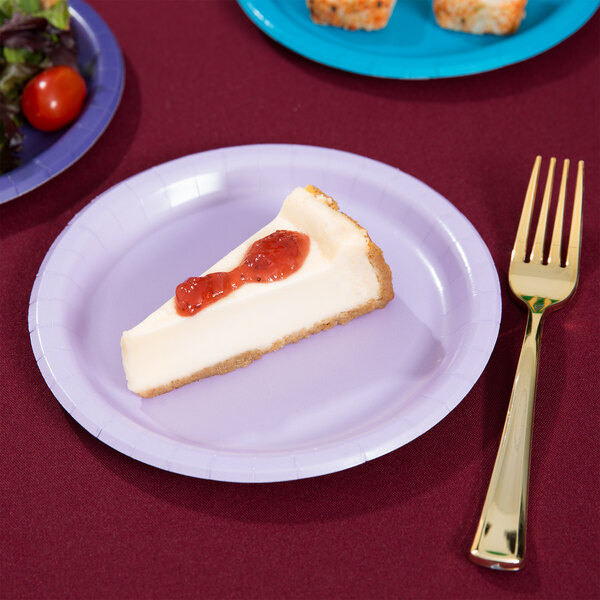 A piece of cheesecake on a Luscious Lavender paper plate with a fork.