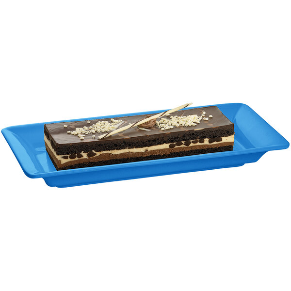 A rectangular piece of chocolate cake on a Tablecraft sky blue cast aluminum rectangular platter.