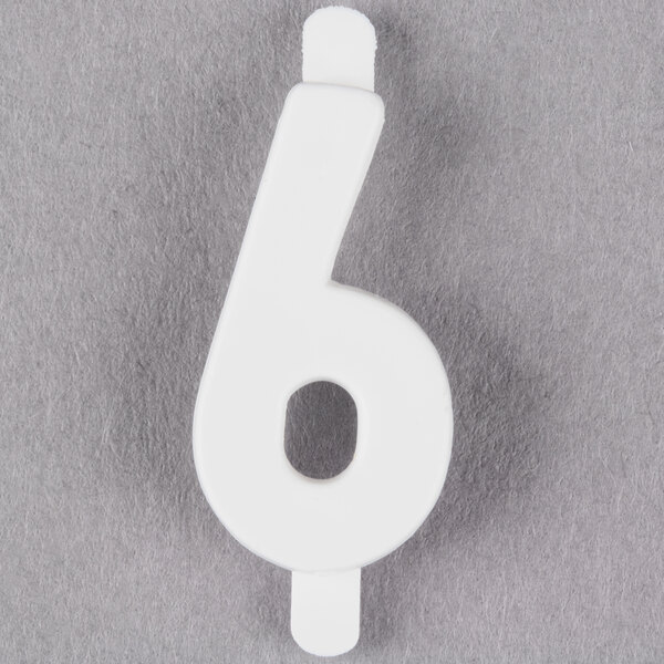 A white number six on a grey surface with the text "Number 6"
