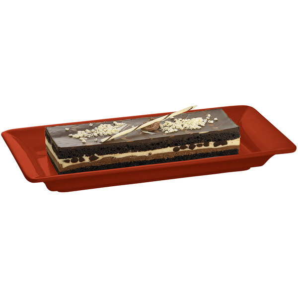 A rectangular brown and white dessert on a copper rectangular platter.