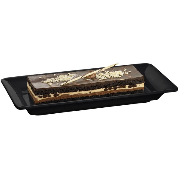 A rectangular black Tablecraft cast aluminum platter with a chocolate cake on it.