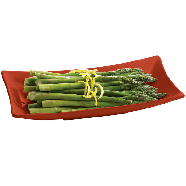 A Tablecraft copper cast aluminum flared rectangle platter with asparagus and lemon zest on a table.