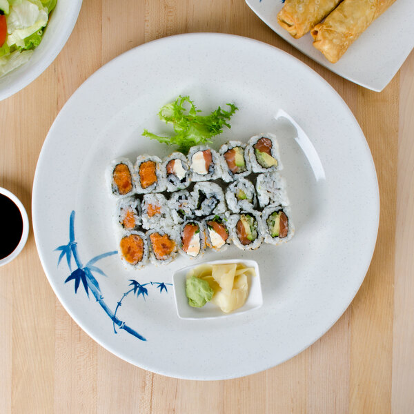 A plate of sushi and salad on a blue and white bamboo Thunder Group melamine plate.