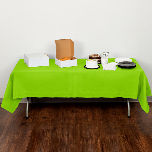 A table with a Fresh Lime Green Creative Converting table cover and food on it.