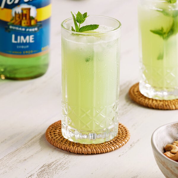 A glass of green Torani lime beverage with mint leaves.