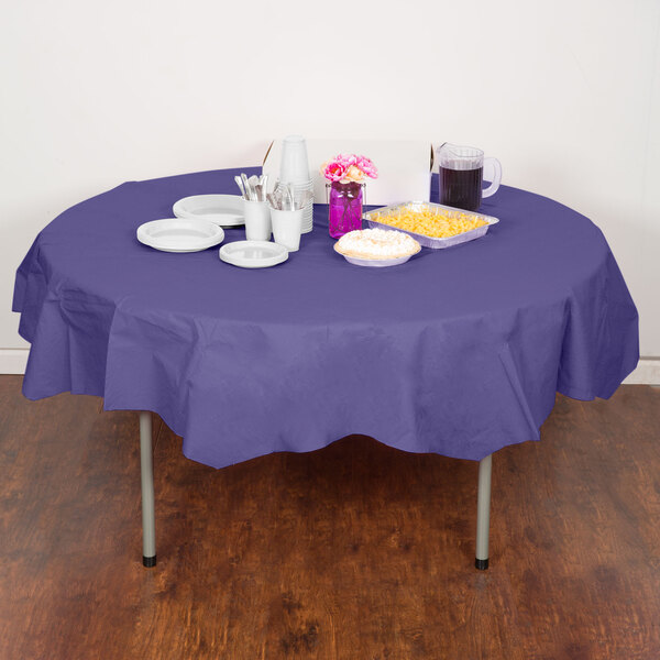 A table with a purple Creative Converting tablecloth, plates, and cups.