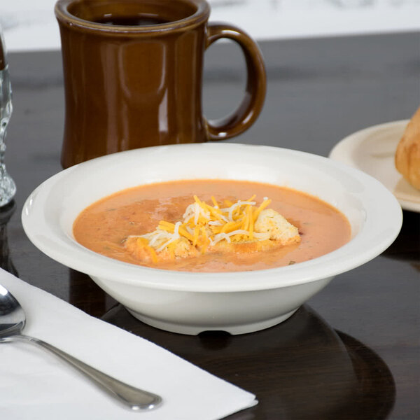 A Diamond Ivory melamine bowl filled with soup topped with cheese and croutons.