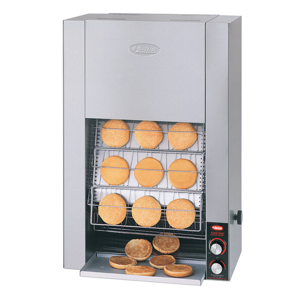 A Hatco Toast King vertical conveyor bun toaster with buns on a wire rack.