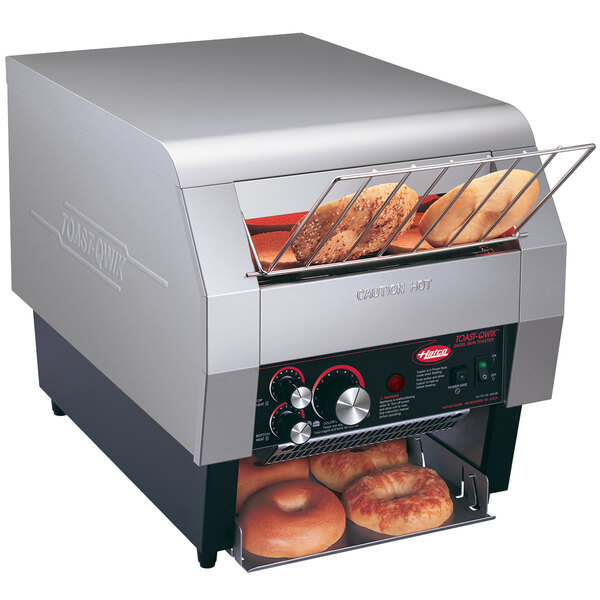 A Hatco conveyor toaster with bagels in it.