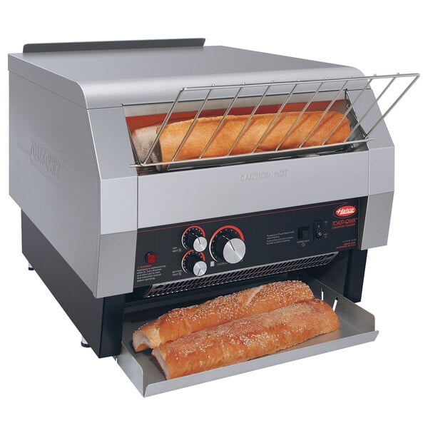 A Hatco commercial conveyor toaster toasting bread.