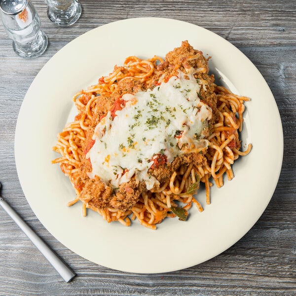 A white Diamond Ivory melamine plate with spaghetti, meat, and cheese on it.