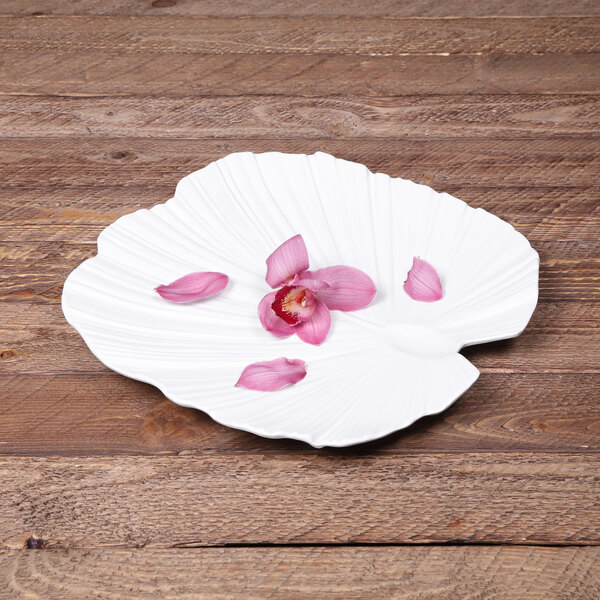 A white Elite Global Solutions melamine platter with pink petals and green leaves.