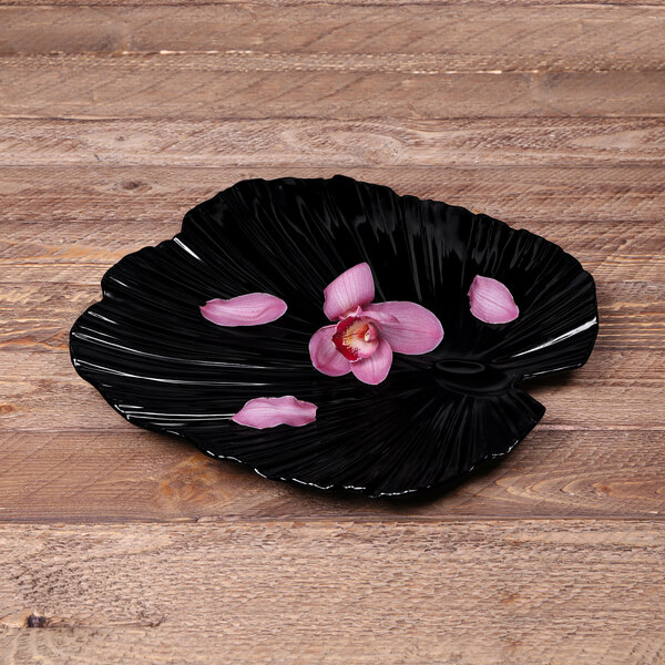 A black melamine platter with a pink flower design.
