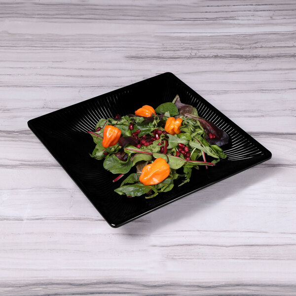 An Elite Global Solutions black square melamine tray with salad on it.