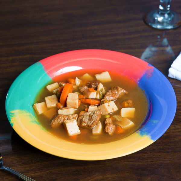 A white melamine bowl with a colorful bowl of soup in it.