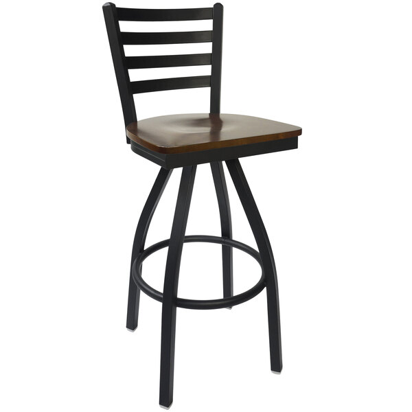 A BFM Seating black steel bar stool with a walnut wood swivel seat.