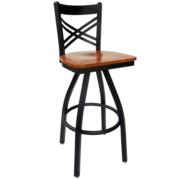 A black metal BFM Seating restaurant bar stool with a cherry wood swivel seat.