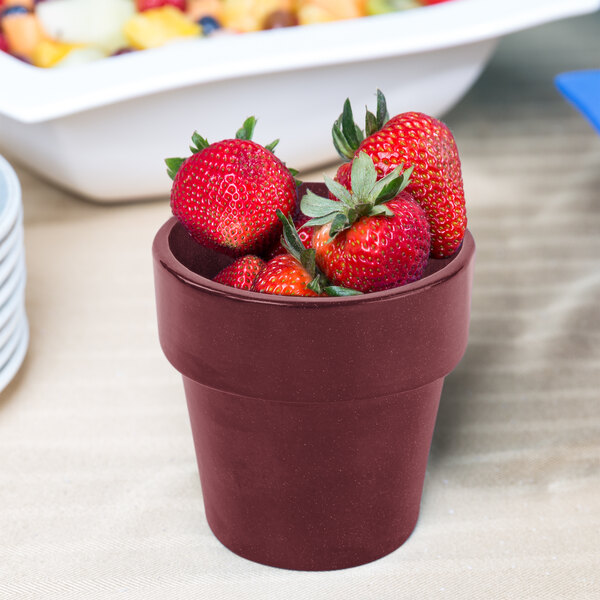 A Tablecraft maroon speckle condiment bowl filled with strawberries on a table.