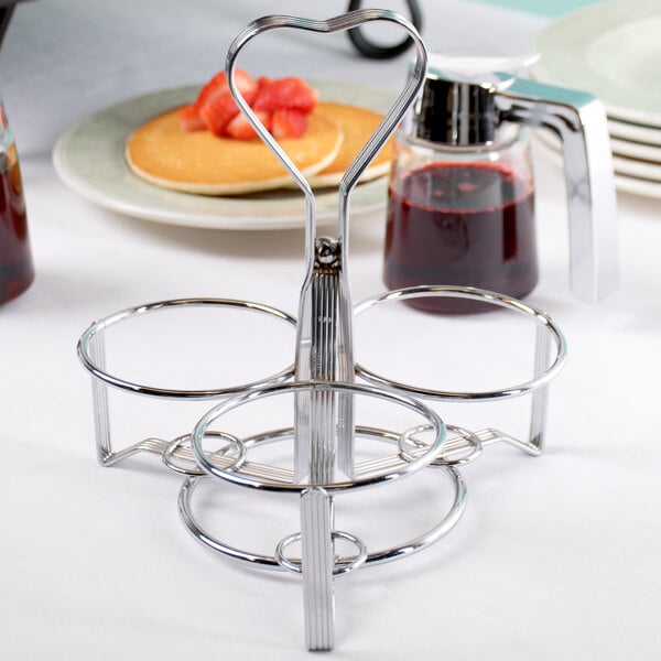A silver metal Tablecraft 3-ring dispenser on a table.