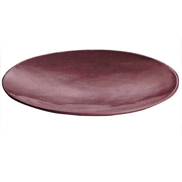 A maroon speckled cast aluminum round flared platter on a table.