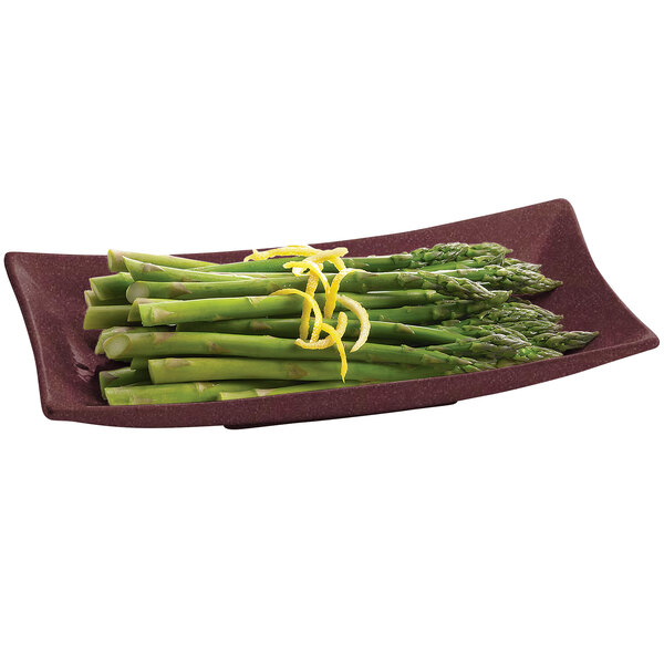 A Tablecraft maroon speckle cast aluminum flared rectangular platter with asparagus and lemon slices on it.