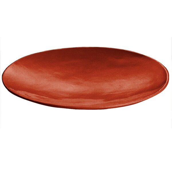 A copper cast aluminum round flared platter on a table with white tablecloth.