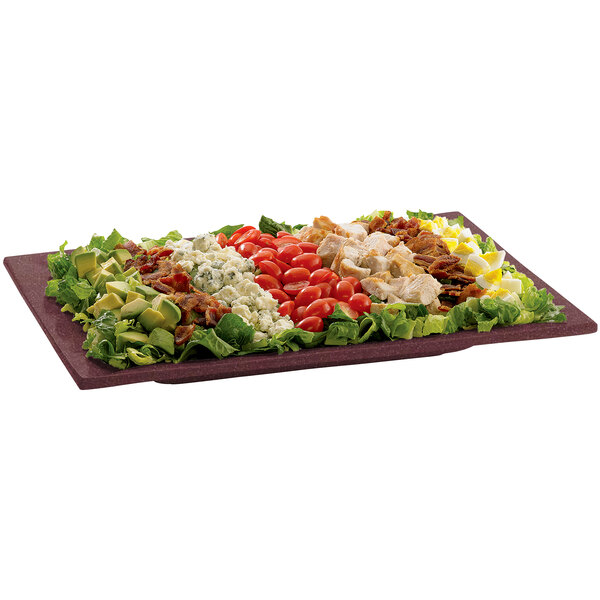 A Tablecraft maroon speckled cast aluminum rectangle platter with a large salad and different toppings.