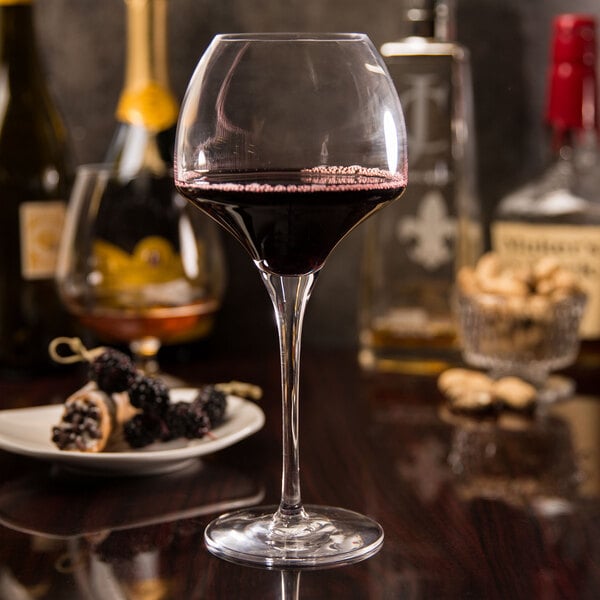 A close-up of a glass of red wine on a table.