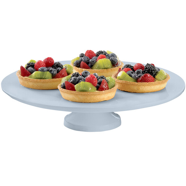 A Tablecraft gray cast aluminum cake stand with four fruit tarts on it.
