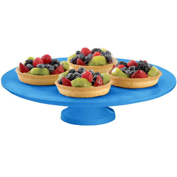 A Tablecraft sky blue cast aluminum round platter with fruit tarts on it.