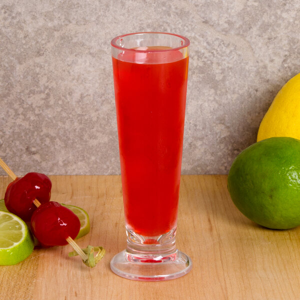 A GET SAN plastic shooter with a red liquid, lime, and cherries.