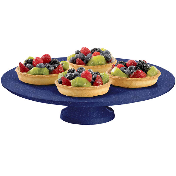 A Tablecraft blue speckled cast aluminum cake stand with fruit on it.