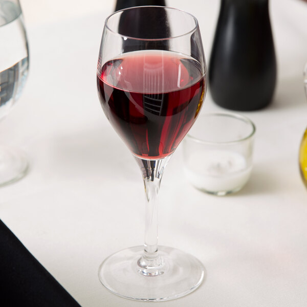 A Chef & Sommelier Exalt wine glass filled with red wine on a table.