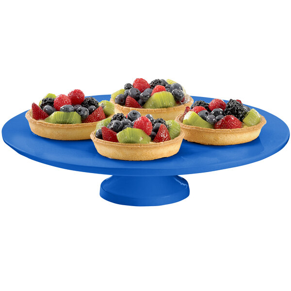 A blue Tablecraft cast aluminum round platter with fruit tarts on it.