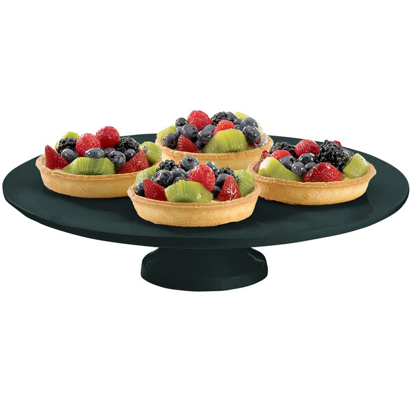 A Tablecraft black cast aluminum cake stand with fruit on it.