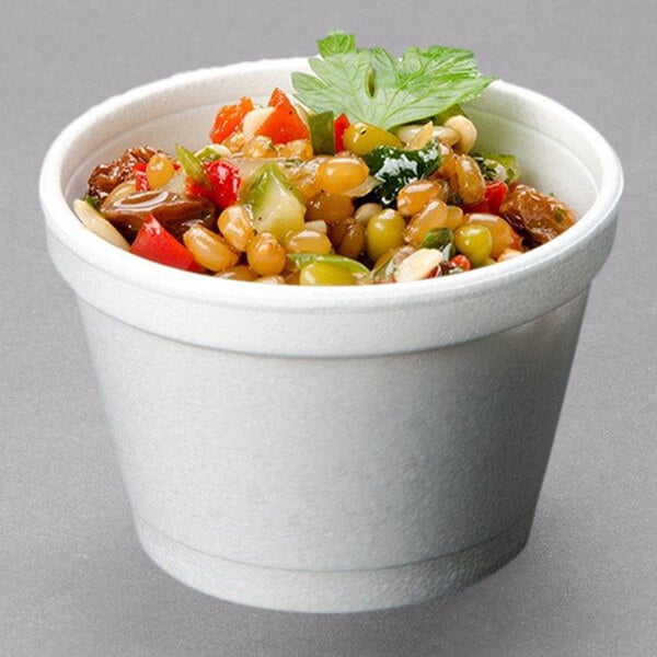 A white Dart foam bowl filled with food and vegetables.