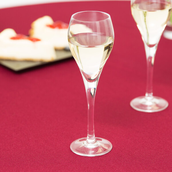 Two Arcoroc Malea Brio wine glasses on a table with wine.