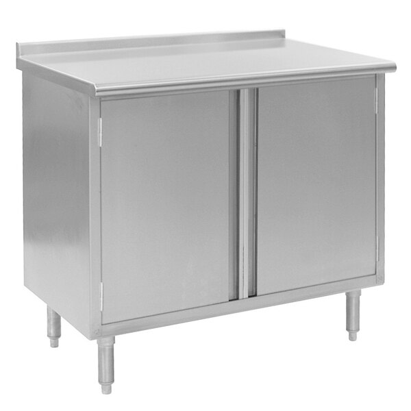 A stainless steel cabinet with two doors on a stainless steel Eagle Group work table.