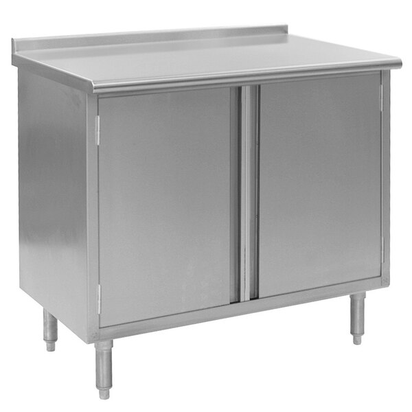 A stainless steel Eagle Group work table with a cabinet base and two doors.