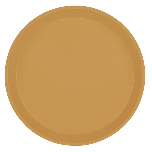 A close-up of a brown Cambro round fiberglass tray with a yellow wall in the background.