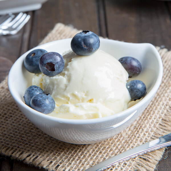 An Arcoroc porcelain deep bowl filled with ice cream and blueberries.