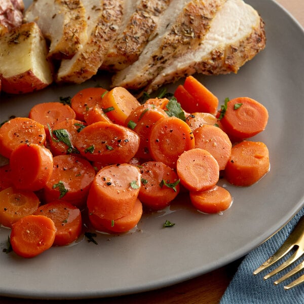 A plate with sliced carrots and chicken.