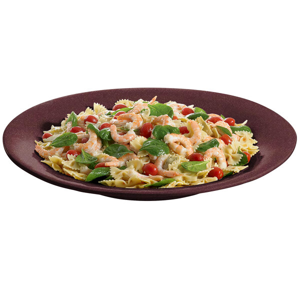 A Tablecraft maroon speckle wide rim platter with a plate of pasta with shrimp and vegetables on a table.